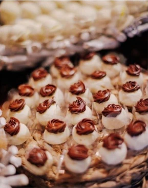 Doces decorados com cobertura de chocolate em uma mesa de festa